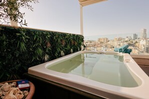 Ein Whirlpool mit Blick auf die Stadt, umgeben von üppigem Grün.