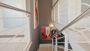Una escalera con barandillas blancas y un cuadro en la pared.