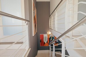 Eine Treppe mit weißen Geländern und einem Gemälde an der Wand.