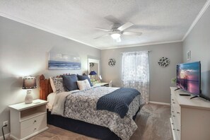 A bedroom with a bed, bedside table, lamp, dresser, and a television. - 2br/2ba Ocean Walk condo for monthly rentals - December through March (Saint Simons Islandd)
