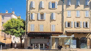 A building with a closed shutter, a sign reading 'ATELIER,' and a visible entrance. - Suite Jungle Premium - Studio climatisé (Toulon)