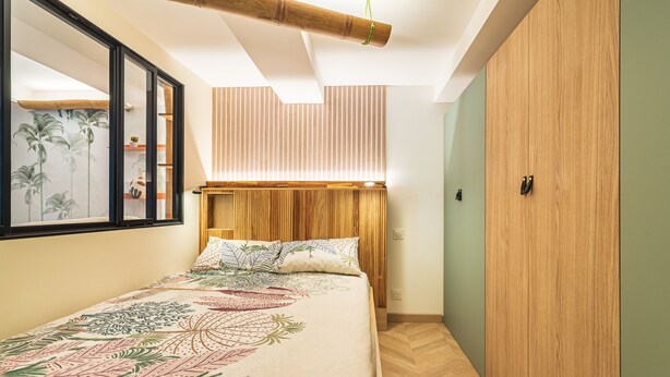 A bedroom with a bed, wooden headboard, a mirror, and a wardrobe. - Suite Jungle Premium - Studio climatisé (Toulon)