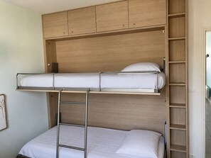 A bunk bed with a ladder, wooden headboard, and a small shelf unit. - La Résidence - Appt avec balcon et vue mer (La Baule)