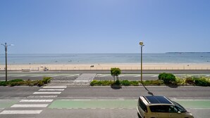 Eine Straße führt zu einem Strand, wo ein Van am Straßenrand geparkt ist.