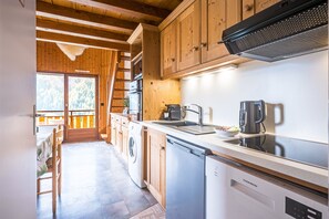 Une cuisine avec des meubles de rangement en bois, un lave-vaisselle et une cuisinière.