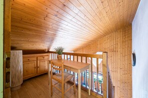A wooden interior with a dining table and chairs, a potted plant, and a view through a window. - Le Prés Vieux - Appt avec balcon et vue montagne (Le Grand Bornand)