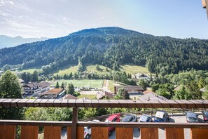 A mountain landscape with a view of a parking area and buildings in the foreground. - Le Prés Vieux - Appt avec balcon et vue montagne (Le Grand Bornand)