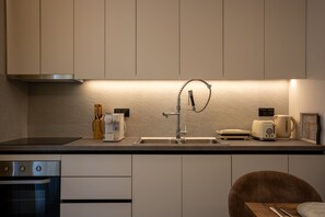 Eine moderne Küche mit eingebautem Geschirrspüler, einer Edelstahl-Spüle und einem Toaster.