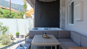 Un espace extérieur moderne aménagé avec un canapé, une table et un jacuzzi.