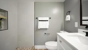 Un baño moderno con inodoro, lavabo y toallero.