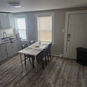 A kitchen with a dining table, chairs, a sink, and cabinets. - Montclair 1st flr Apt/w Porch|Easy Access to NYC (Montclair)