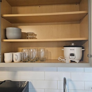 A kitchen with wooden shelves, a slow cooker, and various glassware. - Montclair 1st flr Apt/w Porch|Easy Access to NYC (Montclair)