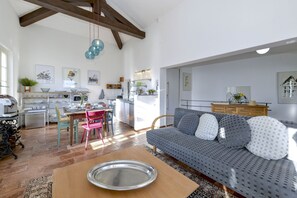A modern kitchen with a dining area, a sofa, and a large window. - Villino Colmenacco (Nesso)