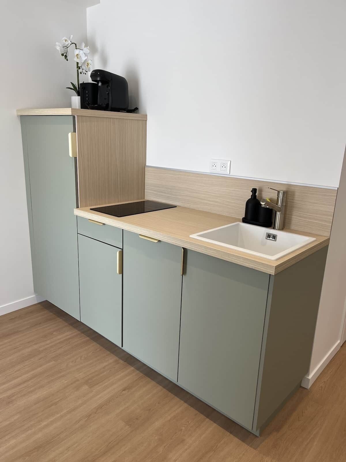 Una cocina compacta con fregadero, encimera y armarios.