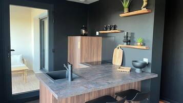 Una cocina moderna con isla integrada, taburetes de bar, un lavamanos y armarios de madera.