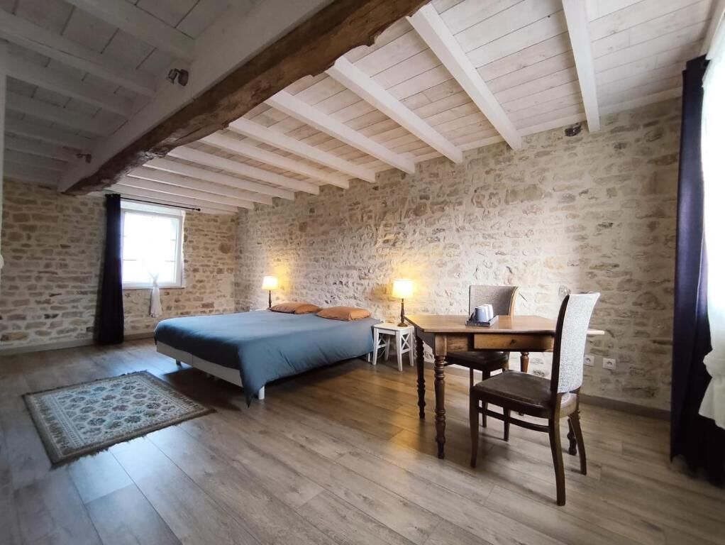 Una camera da letto con un letto, un comodino, una lampada e una sedia.
