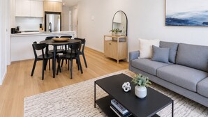 Un appartamento moderno con zona pranzo, cucina, soggiorno e un'ampia finestra.