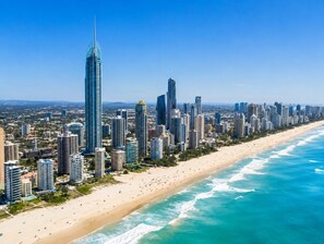 Un paisaje urbano costero con edificios altos, una playa arenosa y el océano.