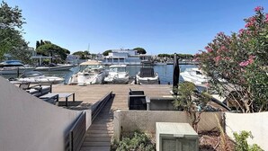 Ein Yachthafen mit vertäuten Booten, ein Holzdeck und Blick auf das Wasser.