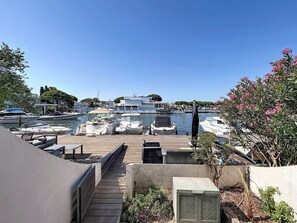 A marina with boats docked, a wooden deck, and a view of the water. - A Pleasant Marina in the DRC (Le Grau-du-Roi)