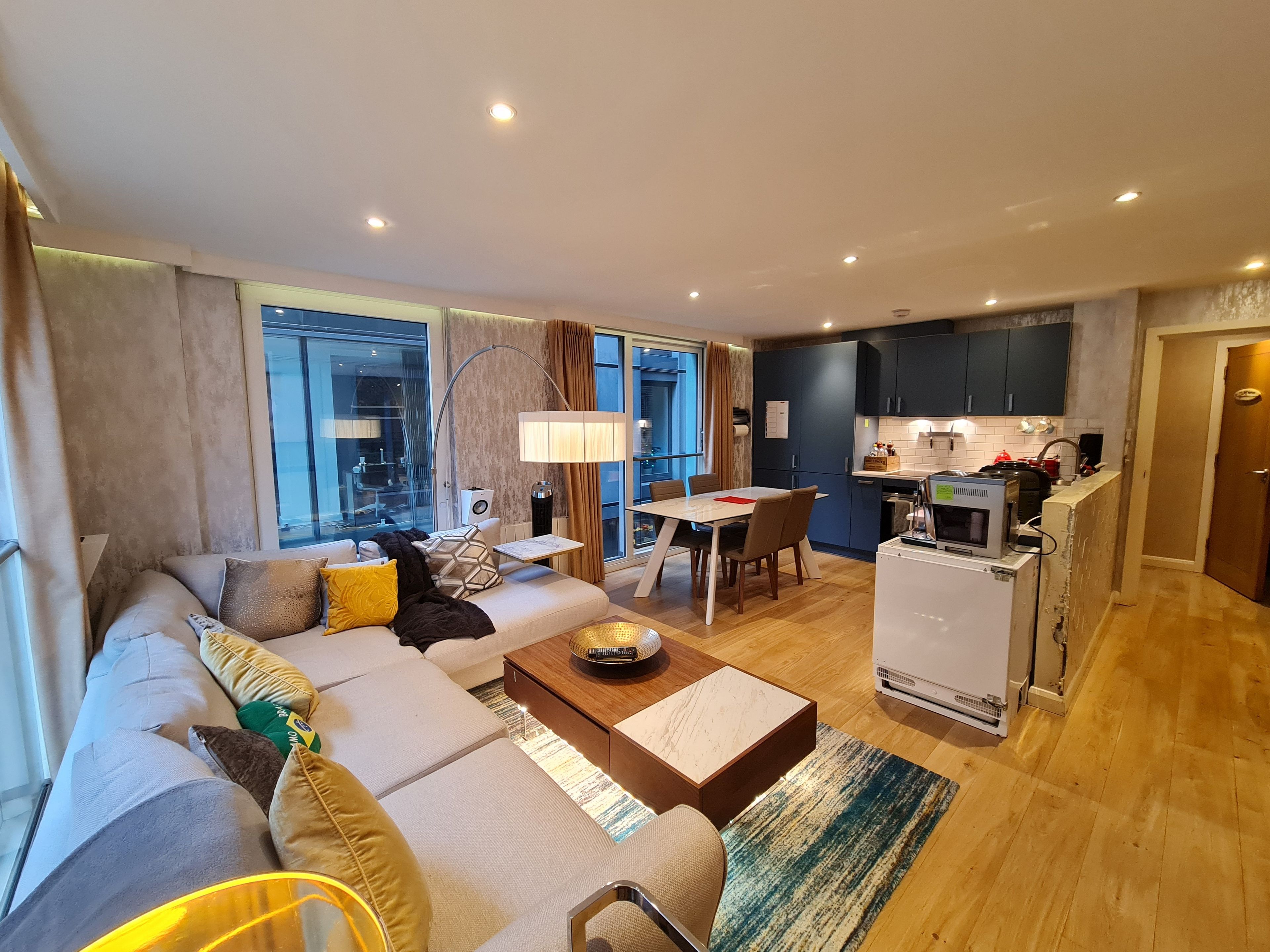 A modern living room with a sofa, coffee table, and dining area.