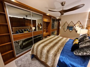 A bedroom with a large bed, a ceiling fan, a wardrobe, and a mirror. - Stylish and Modern 1BDR in Farringdon London (London)