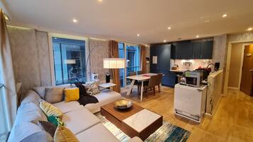 A modern living room with a sofa, coffee table, and dining area.