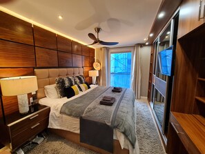 A modern bedroom with a large bed, a ceiling fan, a TV, and a view of the outside. - Stylish and Modern 1BDR in Farringdon London (London)
