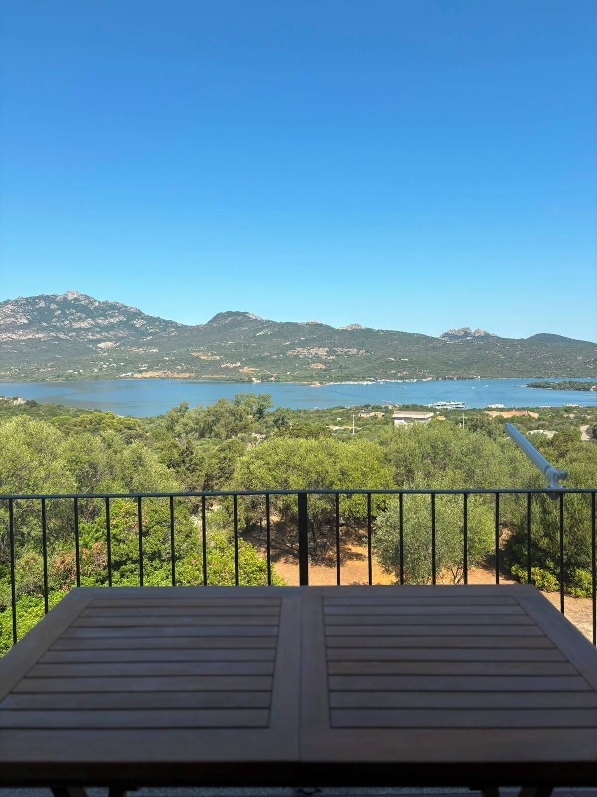 Uma varanda com vista para um lago e montanhas.