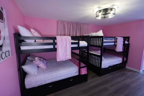 A room with bunk beds, a pink wall, and a ceiling light fixture. - Modern Pink Home, Pool-Karaoke-Photo Ops (Houston)