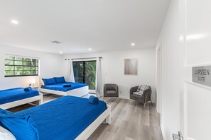 Una habitación de hotel moderna con dos camas, una zona de estar y una ventana con vistas.