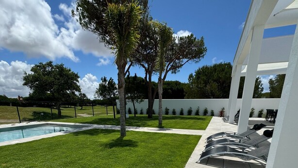 A modern outdoor area with a swimming pool, a grassy lawn, and a patio with lounge chairs. - PONIENTE BEACH HOUSE New Luxury independent villa 4suite bedroom NovoSancti Petr (Chiclana de la Frontera)