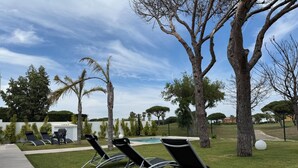 A poolside area with lounge chairs and a clear sky. - PONIENTE BEACH HOUSE New Luxury independent villa 4suite bedroom NovoSancti Petr (Chiclana de la Frontera)
