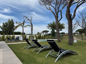 A poolside area with lounge chairs and a clear sky. - PONIENTE BEACH HOUSE New Luxury independent villa 4suite bedroom NovoSancti Petr (Chiclana de la Frontera)