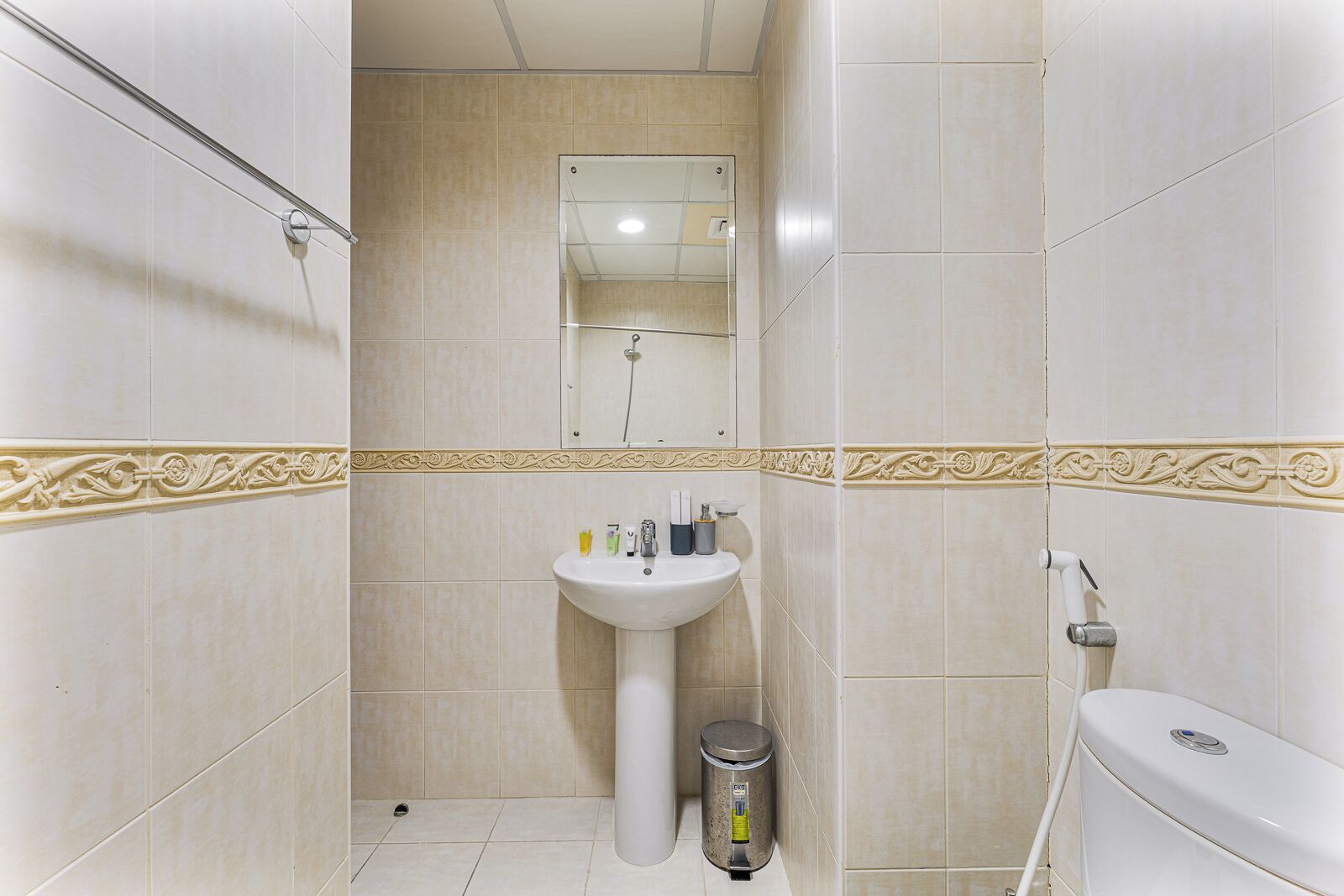 Een badkamer met wastafel, spiegel, toilet en douche.
