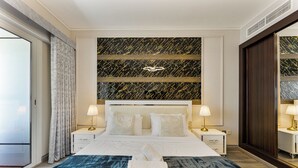 A hotel room with a large bed, two bedside tables, a marble-patterned wall, and a large window. - Grand 5BR near JBR Beach, Dubai Marina (Dubai)