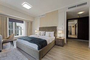 Une chambre d’hôtel avec un grand lit, une chaise, une table de chevet et une vue sur la ville.