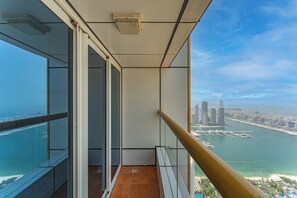 Ein Balkon mit Blick auf die Stadt, einem Geländer und einer Tür zu einem Innenraum.