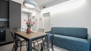 Una cocina moderna con una mesa de comedor, sillas y un florero con flores.