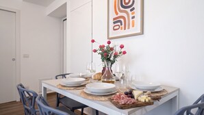 Ett matbord med tallrikar, glas, en vas med blommor och en ostbricka.