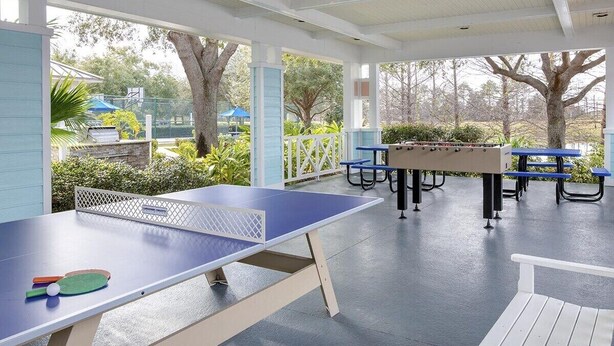 Ein Indoor-Freizeitareal mit Tischtennisplatte, Sitzgelegenheiten und Blick ins Freie.