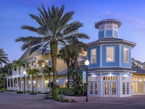 A hotel with a distinctive blue tower, a covered outdoor area, and palm trees. - 2 Bedroom Villa at Harbour Lake Family-Friendly (Orlando)