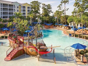 A pool area with a pirate ship play structure, lounge chairs, and umbrellas. - 2 Bedroom Villa at Harbour Lake Family-Friendly (Orlando)