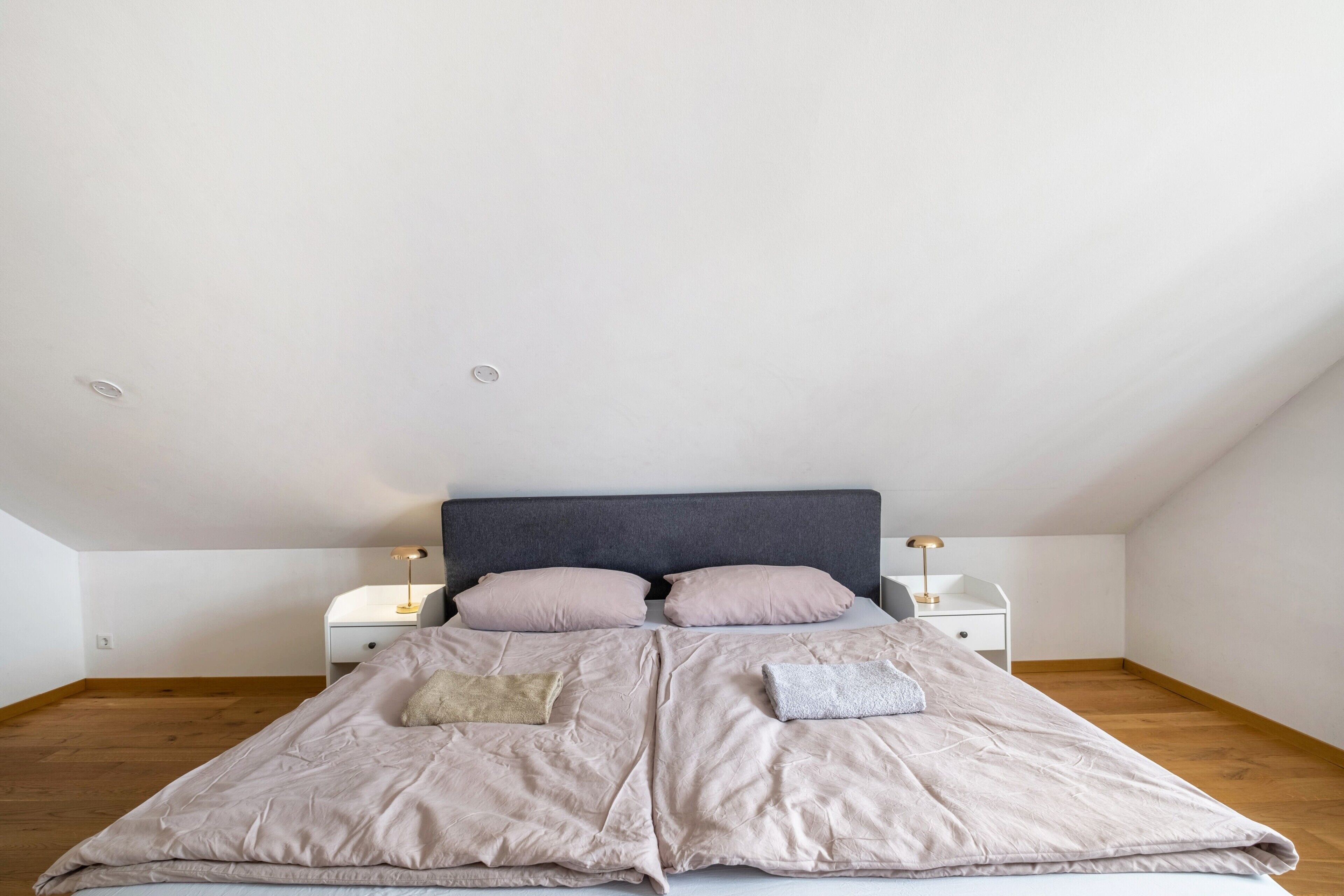 Une chambre à coucher avec un lit, deux tables de chevet et une commode.