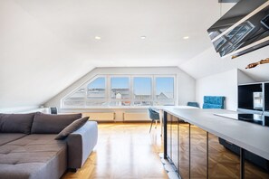 Um loft moderno com um amplo claraboia, área de jantar e sofá.