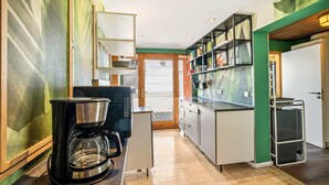 A compact kitchen with a coffee machine, a refrigerator, and a microwave. - Apartment 'Loft Character' with Wi-Fi (Hofheim)
