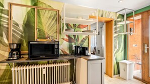 A compact kitchen with a microwave, coffee maker, and a radiator. - Apartment 'Loft Character' with Wi-Fi (Hofheim)
