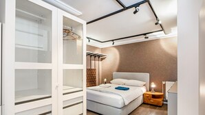 Un dormitorio con cama, mesita de noche, lámpara y un vestidor con estantes.