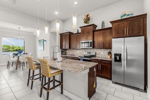 A modern kitchen with granite countertops, stainless steel appliances, and wooden cabinets. - Waterfront Paradise with Hot Tub, near 5th Ave (Cape Coral)