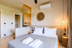 Une chambre d’hôtel équipée d’un lit, d’une table de chevet, d’un miroir, d’un climatiseur et d’un luminaire fixé au mur.